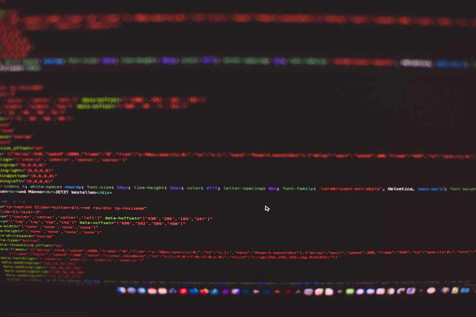 Close-up view of a MacBook Air laptop displaying a screen filled with lines of colorful code, indicating programming or web development work. The background features a warm, orange-hued wall, creating